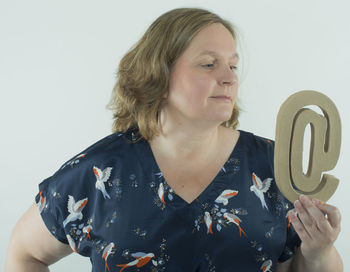 Close-up of young woman holding camera over white background
