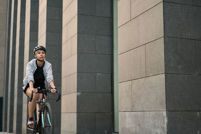 Full length of man riding bicycle in city