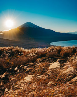 Scenic view of mountains against bright sun