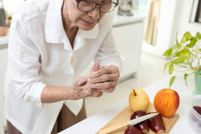 Senior woman got injured while cutting fruits