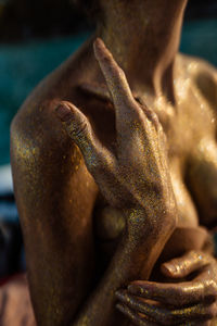 Close-up of a female body covered in gold