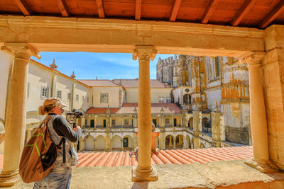 Woman photographing buildings in city