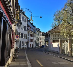 Empty road with buildings in background