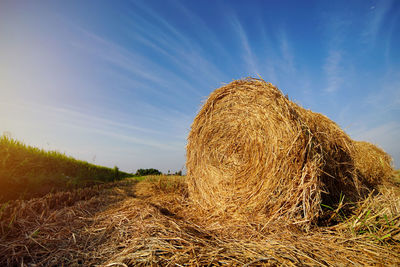 Hay bales on field against sky