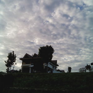 Silhouette of trees on field against sky