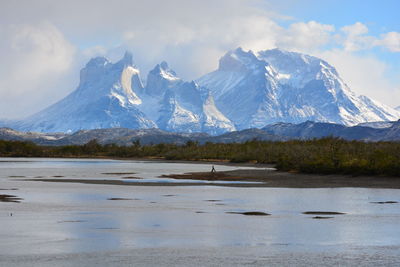 Scenic view of lake by mountains against sky