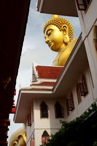 Low angle view of young woman standing against building