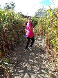 Full length portrait of woman standing on field