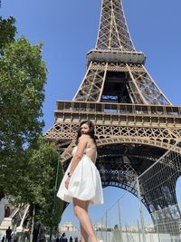 Low angle view of woman standing against sky