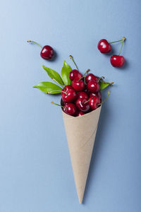High angle view of cherries against blue background