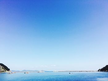 Boats in sea against clear sky