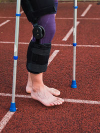 Hurt runner walk by forearm crutches on running track after finished competition on  outdoor stadium