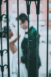 Couple seen through window standing in city