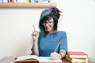 Young woman sitting on table at home