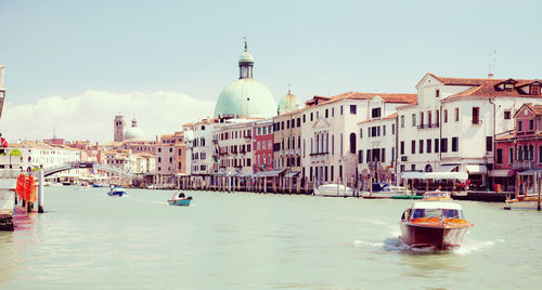 Boats in canal with buildings in background