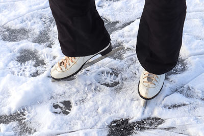 Low section of person standing on snow covered land