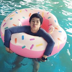 Portrait of boy puckering lips in inflatable ring on swimming pool