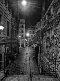 Street amidst buildings in city at night