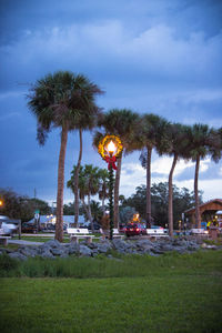 Palm trees against cloudy sky
