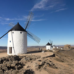 Traditional windmill on land against sky