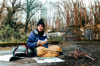 Full length of man sitting in park during winter