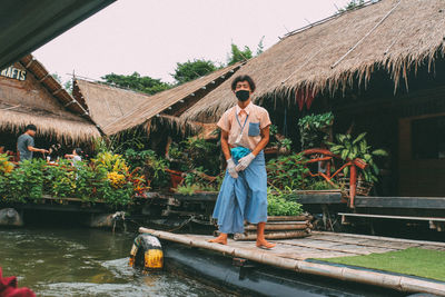 Full length of man standing by house against building