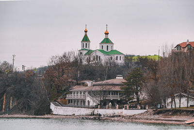 View of buildings and trees against clear sky