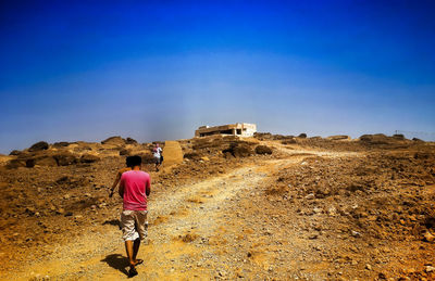 Full length of woman standing against clear blue sky