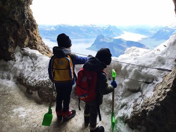 Rear view of children standing on cliff