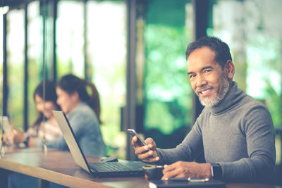 Portrait of smiling man sitting on table