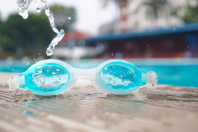 Close-up of wet swimming goggles at swimming pool