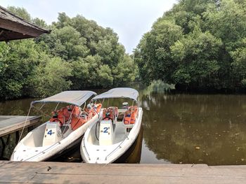 Boats moored in lake against sky