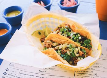 High angle view of taco with sauce and salad served on table