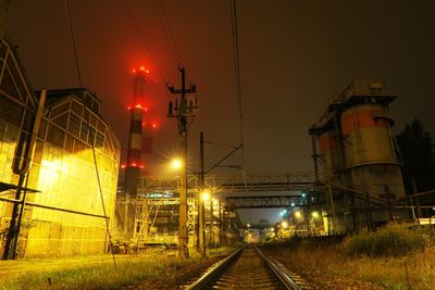 Railroad tracks against sky at night