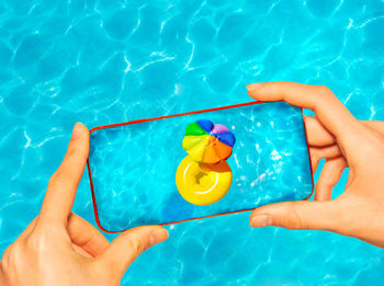 Cropped hands of woman holding swimming in pool