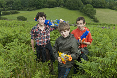 Three teenage boys playing with their toy guns