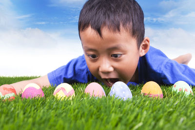 Close-up of boy looking at easter eggs against sky