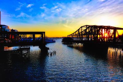 Silhouette pier over sea against sky during sunset