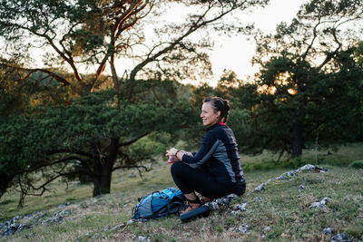 Side view of man sitting on land