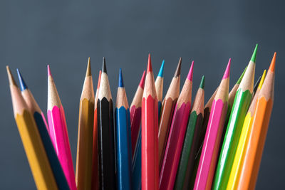 Close-up of multi colored pencils against gray background