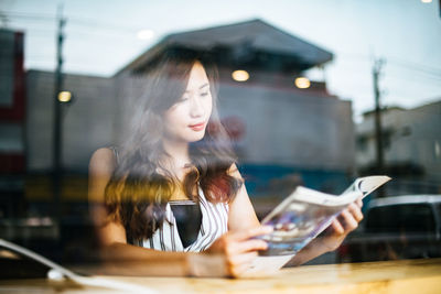 Woman looking at camera while sitting on table