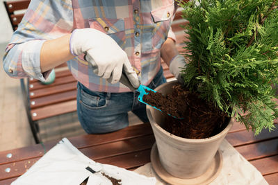 Midsection of woman holding potted plant