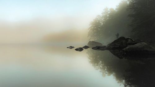 Reflection of rocks in lake against sky