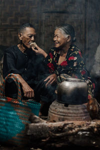 Side view of young friends sitting on wall