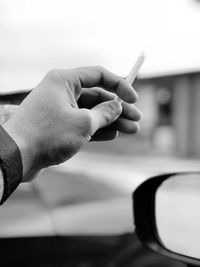 Close-up of man hand holding cigarette in convertible