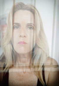 Portrait of beautiful woman reflecting on glass