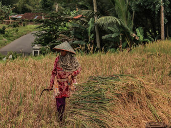 Rear view of woman standing on field