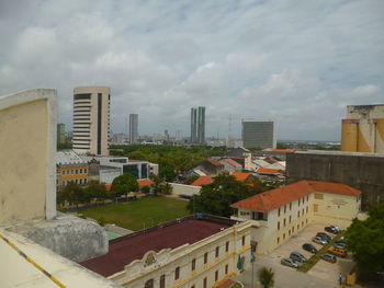 Buildings in city against cloudy sky