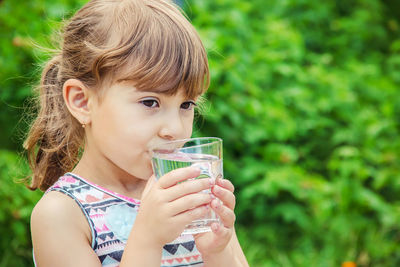 Portrait of cute girl blowing bubbles in park