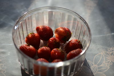 High angle view of strawberries in glass container on table
